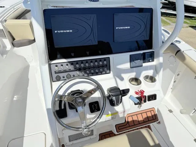 Slide: The Image of 2022 Tidewater 256 CC Adventure boat dashboard with dual Furuno displays and steering wheel. - 10