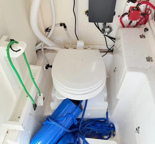 Slide: The Image of 2022 Tidewater 256 CC Adventure boat interior with marine toilet and storage area. - 18