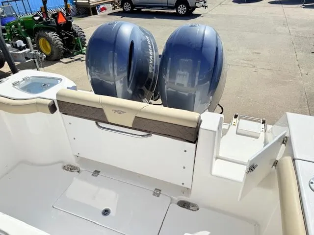 Slide: The Image of 2022 Tidewater 256 CC Adventure boat with dual outboard engines, docked on a sunny day. - 6