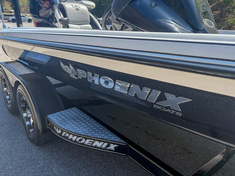 Slide: The Image of 2023 Phoenix 721 ProXP boat, sleek black design with logo, parked on a trailer. - 14