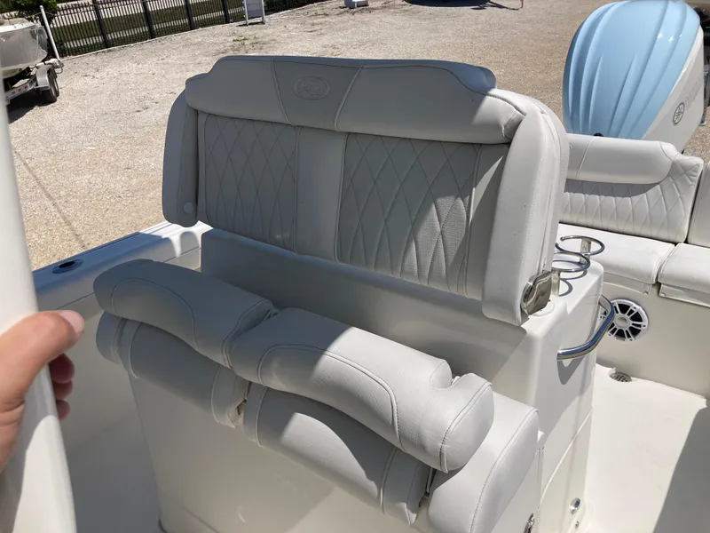 Slide: The Image of 2025 Key West 239FS boat interior with white cushioned seating and cup holders. - 16