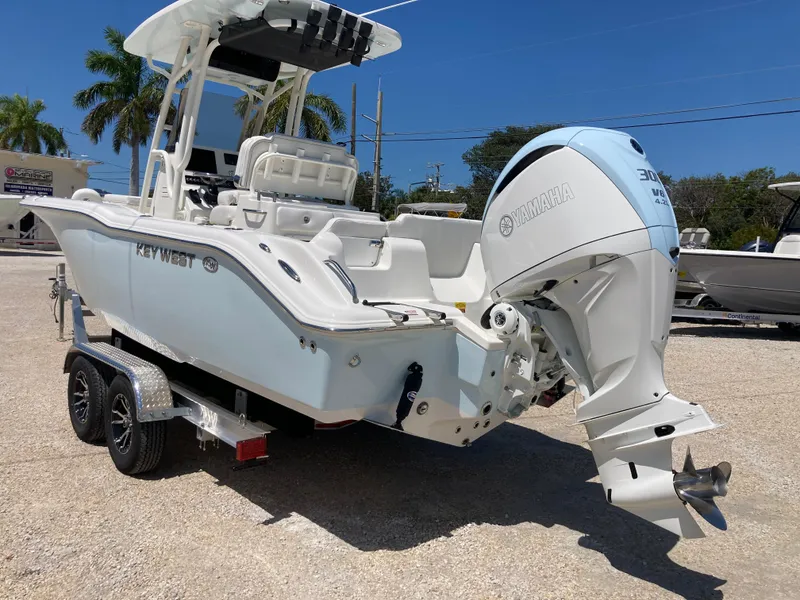 Slide: The Image of 2025 Key West 239FS boat on trailer with powerful outboard motor, parked outdoors. - 4