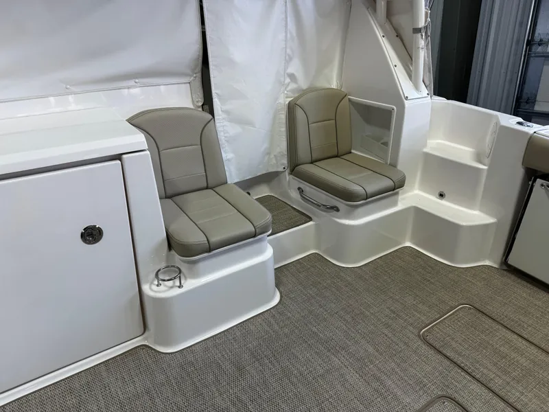 Slide: The Image of 2018 Pursuit OS 355 Offshore boat interior with cushioned seating and storage. - 12