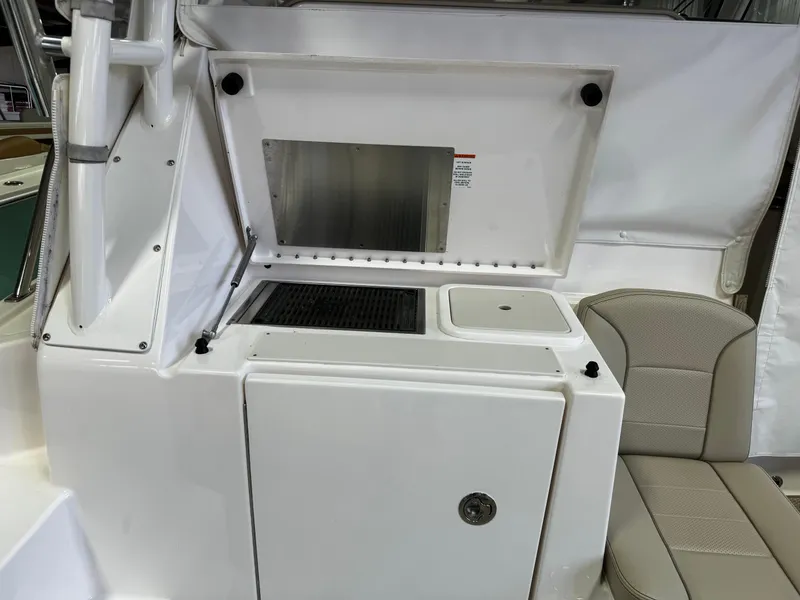 Slide: The Image of 2018 Pursuit OS 355 Offshore boat interior with kitchenette and seating area. - 13