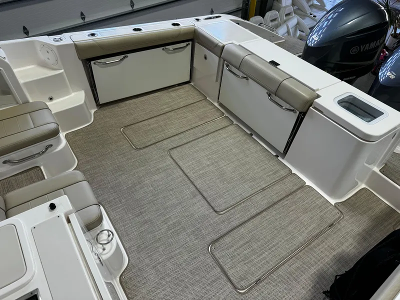 Slide: The Image of 2018 Pursuit OS 355 Offshore boat interior with cushioned seating and storage compartments. - 14