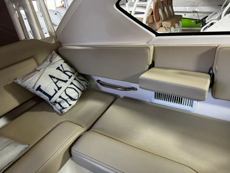 Slide: The Image of 2018 Pursuit OS 355 Offshore interior with beige seating and "Lake House" pillow. - 16