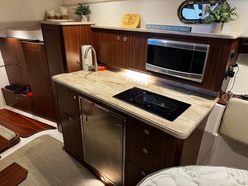 Slide: The Image of Luxurious 2018 Pursuit OS 355 Offshore yacht kitchen with modern appliances and elegant wood cabinetry. - 29