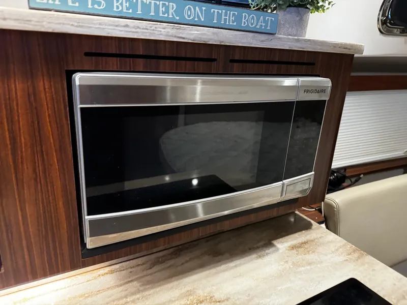 Slide: The Image of Microwave in 2018 Pursuit OS 355 Offshore boat kitchen, wood paneling, countertop. - 30