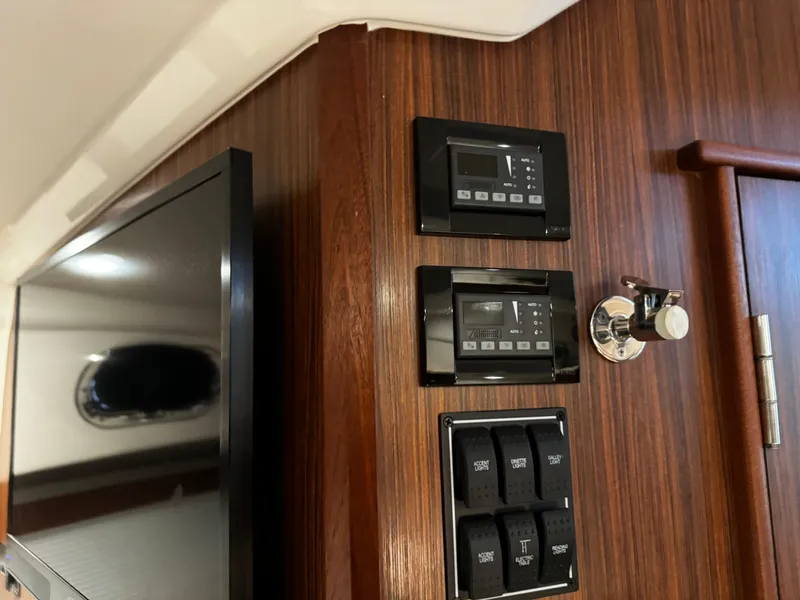 Slide: The Image of 2018 Pursuit OS 355 Offshore interior with control panels and a mounted TV. - 35