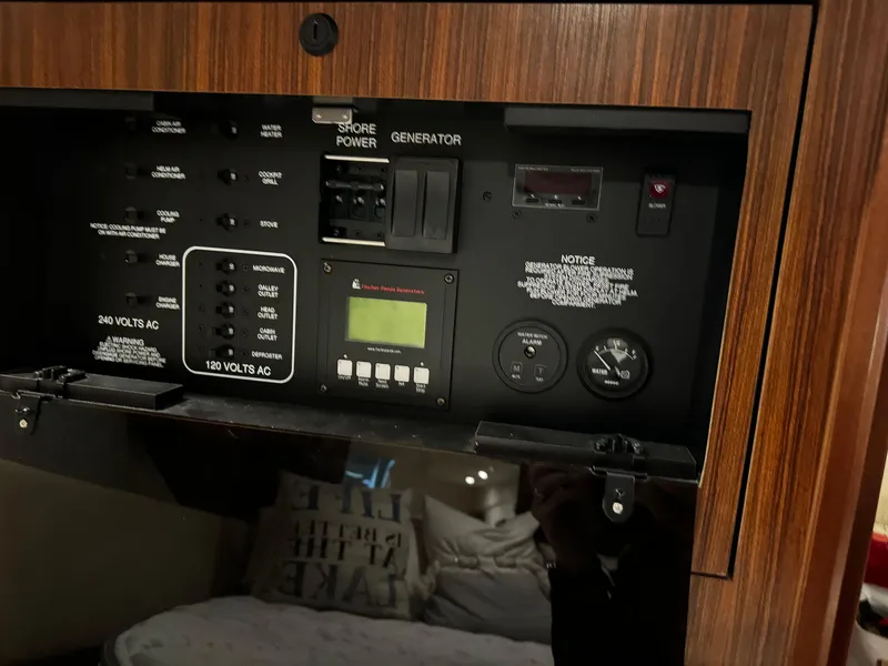 Slide: The Image of Control panel of a 2018 Pursuit OS 355 Offshore boat, featuring power and generator switches. - 36