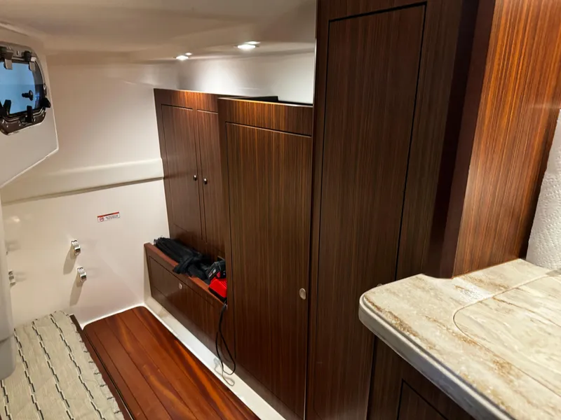 Slide: The Image of 2018 Pursuit OS 355 Offshore cabin interior with wood paneling and storage cabinets. - 37