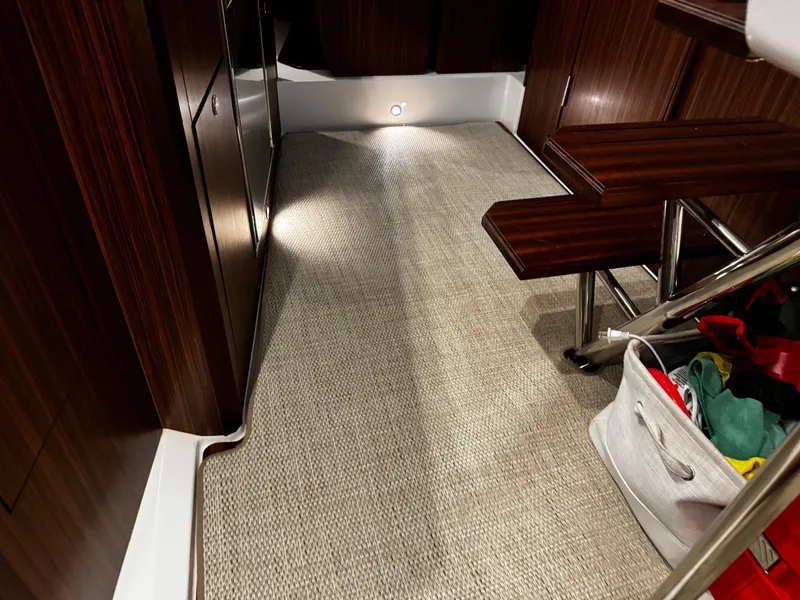 Slide: The Image of 2018 Pursuit OS 355 Offshore cabin interior with carpeted floor and wooden steps. - 39
