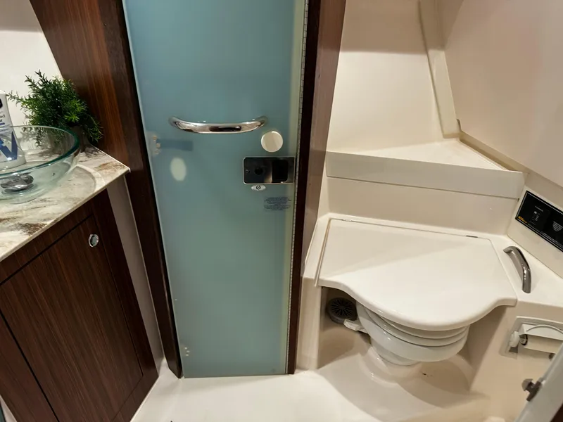 Slide: The Image of 2018 Pursuit OS 355 Offshore bathroom with modern fixtures and frosted glass door. - 41