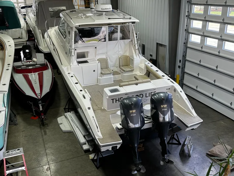 Slide: The Image of 2018 Pursuit OS 355 Offshore boat with twin V8 engines in a garage. - 48