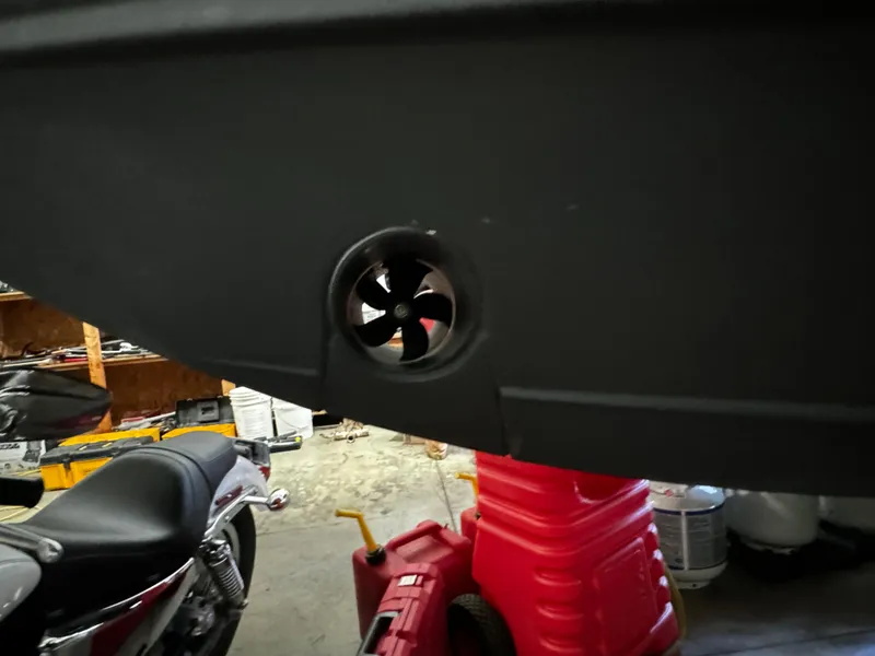 Slide: The Image of 2018 Pursuit OS 355 Offshore boat hull with visible thruster in a garage setting. - 5