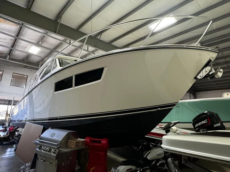 Slide: The Image of 2018 Pursuit OS 355 Offshore boat in indoor storage, viewed from below. - 7
