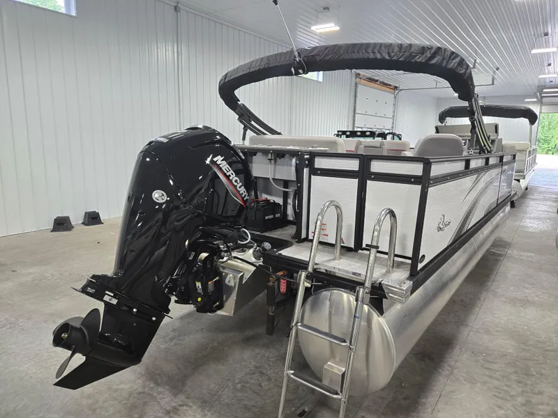 Slide: The Image of 2024 Qwest Angler Qwest XRE pontoon boat with Mercury outboard motor in a garage. - 3