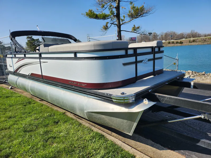 Slide: The Image of 2024 Qwest Angler Qwest XRE pontoon boat on trailer by a lake. - 8