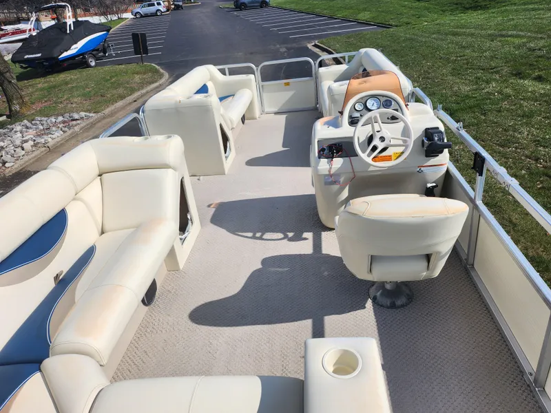 Slide: The Image of 2007 Odyssey Pontoons 222C with spacious seating and steering console, parked on grass. - 17