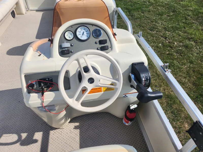 Slide: The Image of 2007 Odyssey Pontoons 222C helm with steering wheel and control panel. - 18