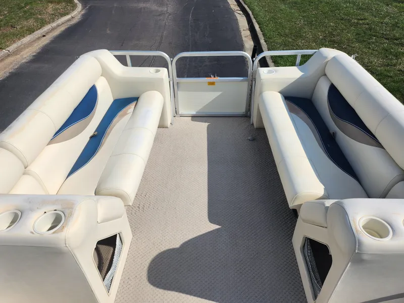 Slide: The Image of 2007 Odyssey Pontoons 222C interior with white and blue seating, cup holders, and open deck space. - 20