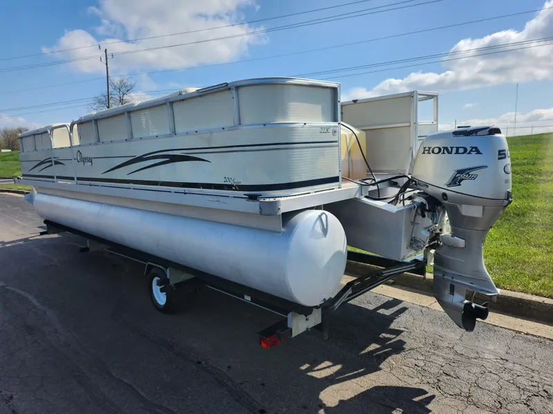 Slide: The Image of 2007 Odyssey Pontoons 222C with Honda outboard motor on a trailer, parked outdoors. - 3