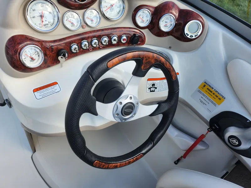 Slide: The Image of Steering wheel and dashboard of 2013 Tahoe Q7i boat with wood accents and gauges. - 14