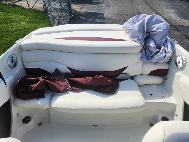 Slide: The Image of 2013 Tahoe Q7i boat interior with white and maroon seating, outdoor setting. - 23