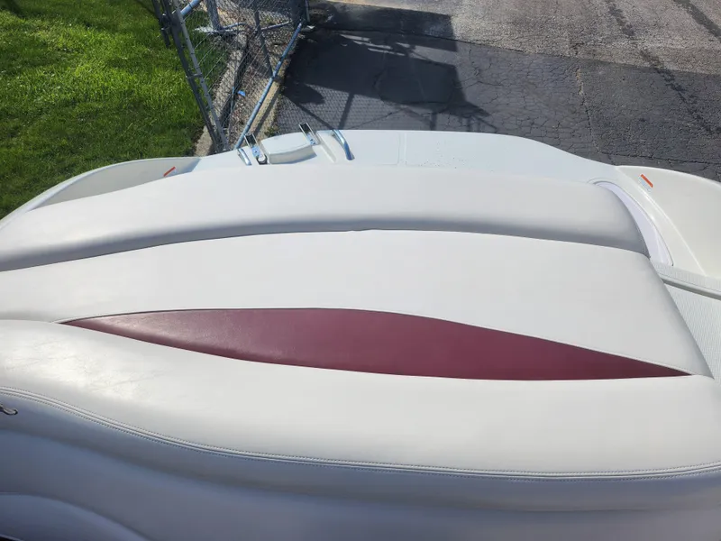 Slide: The Image of 2013 Tahoe Q7i boat with white and red seating, parked on pavement. - 24