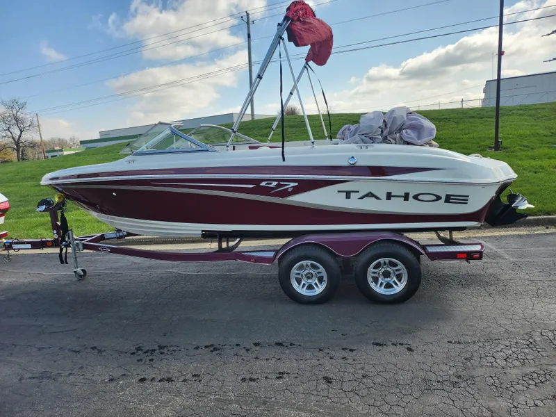 Slide: The Image of 2013 Tahoe Q7i boat on trailer, parked outdoors under a cloudy sky. - 4