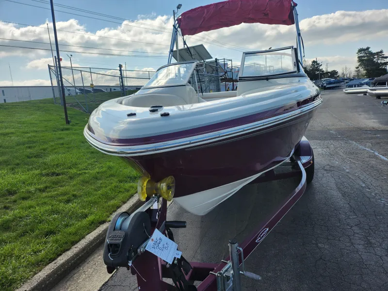 Slide: The Image of 2013 Tahoe Q7i boat on trailer, parked outdoors under a cloudy sky. - 6