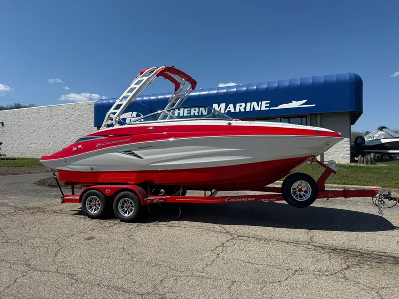 The Image of 2025 Crownline Eclipse E235 boat on trailer, red and white design, parked outdoors. - 0