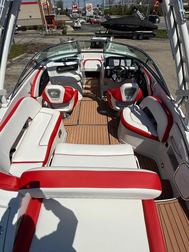 Slide: The Image of 2025 Crownline Eclipse E235 boat interior with red and white seating and wood flooring. - 5