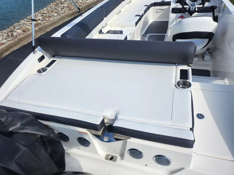 Slide: The Image of 2021 Bayliner DX 2000 boat interior with seating and cup holders near the water. - 10