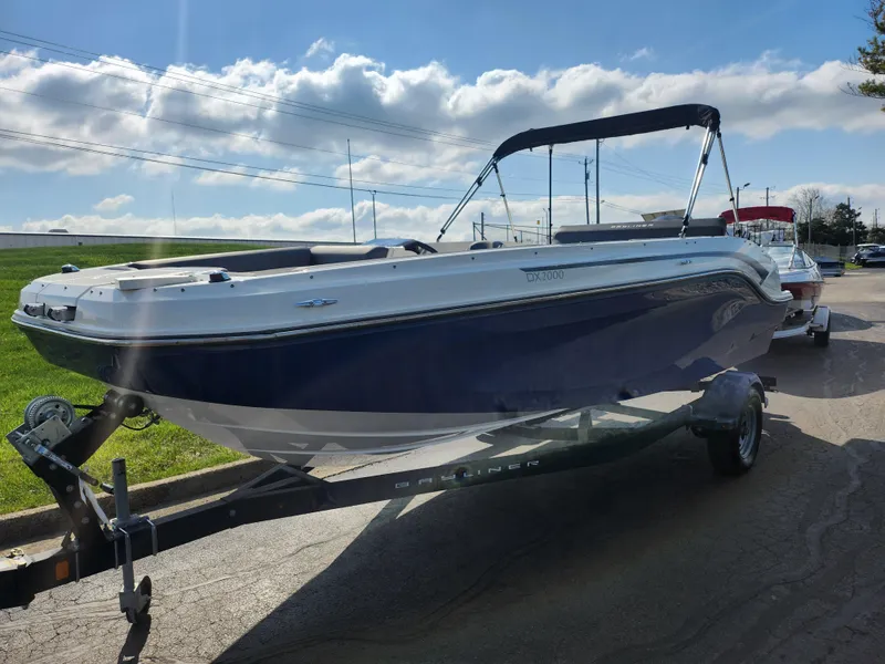 Slide: The Image of 2021 Bayliner DX 2000 boat on trailer under sunny sky. - 5