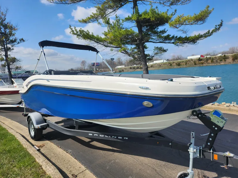 Slide: The Image of 2021 Bayliner DX 2000 boat on trailer by a lakeside, under a clear blue sky. - 8