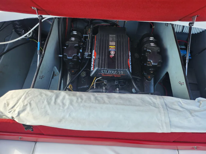 Slide: The Image of 1997 Bayliner 2050 Capri SS engine compartment with red cover and visible engine components. - 22