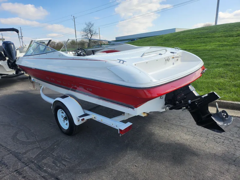 Slide: The Image of 1997 Bayliner 2050 Capri SS boat on trailer, red and white design, parked outdoors. - 3