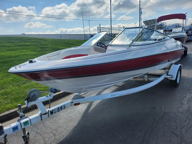 Slide: The Image of 1997 Bayliner 2050 Capri SS boat on trailer, parked outdoors under a cloudy sky. - 5