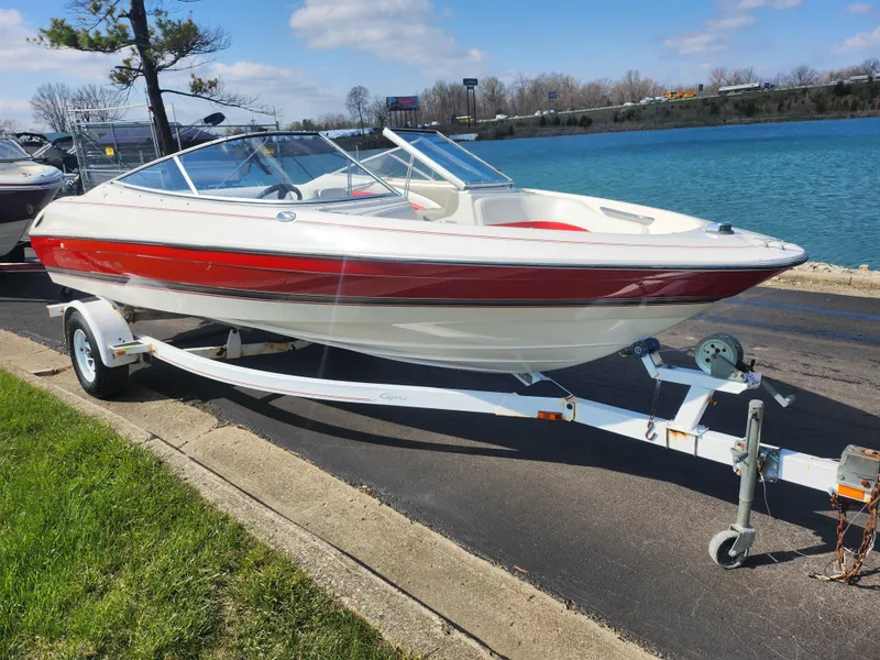 Slide: The Image of 1997 Bayliner 2050 Capri SS boat on trailer by a lake. - 8