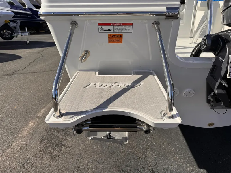 Slide: The Image of 2025 Parker 18SE Center Console boat swim platform with ladder, displayed outdoors. - 42
