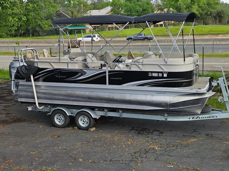 Slide: The Image of 2018 Apex Marine Qwest LS 820 RLS pontoon boat on trailer, parked outdoors. - 1