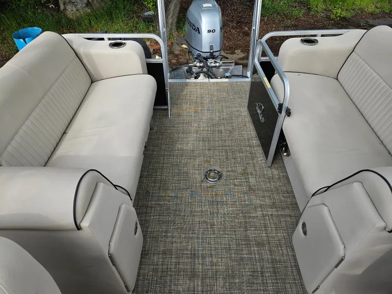 Slide: The Image of 2018 Apex Marine Qwest LS 820 RLS pontoon boat interior with beige seating and Honda motor. - 10