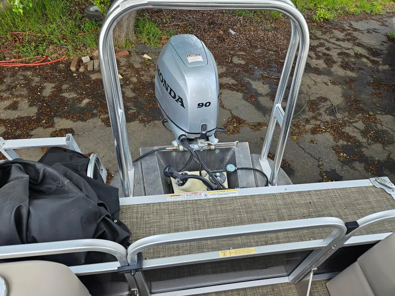Slide: The Image of 2018 Apex Marine Qwest LS 820 RLS with Honda 90 outboard motor, docked on a paved surface. - 5