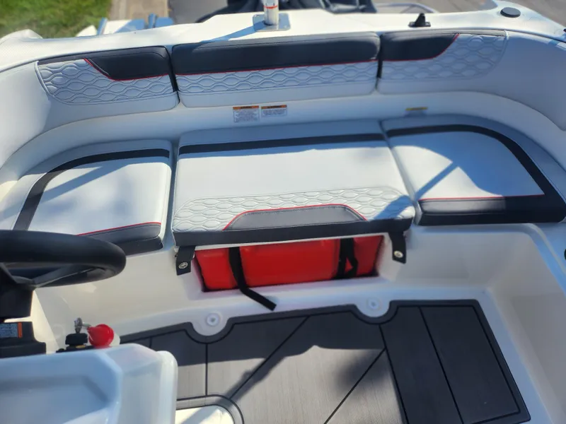 Slide: The Image of 2023 Bayliner Element M15 boat interior with cushioned seating and storage compartment. - 17