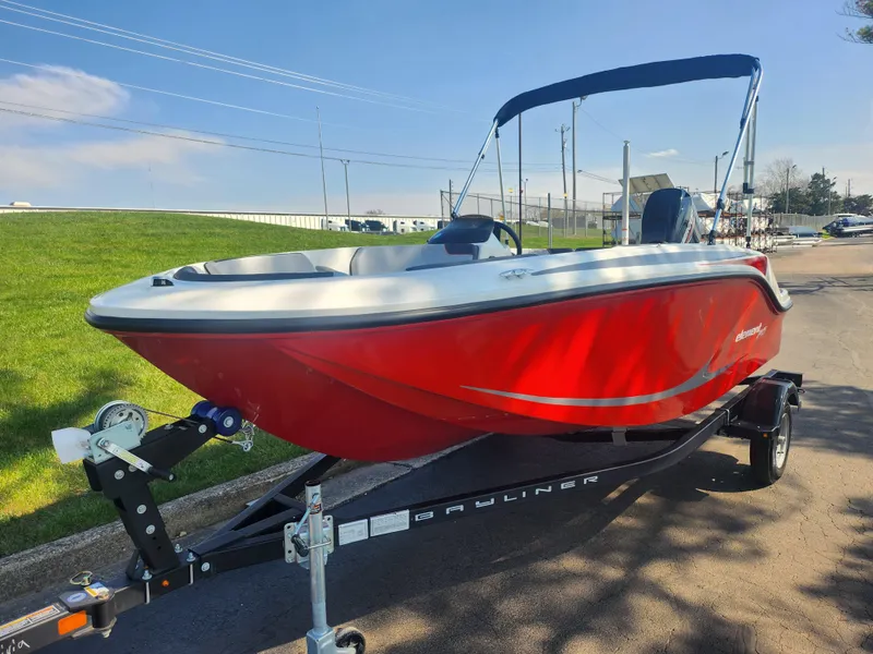 Slide: The Image of 2023 Bayliner Element M15 boat in vibrant red on a trailer, parked outdoors. - 5