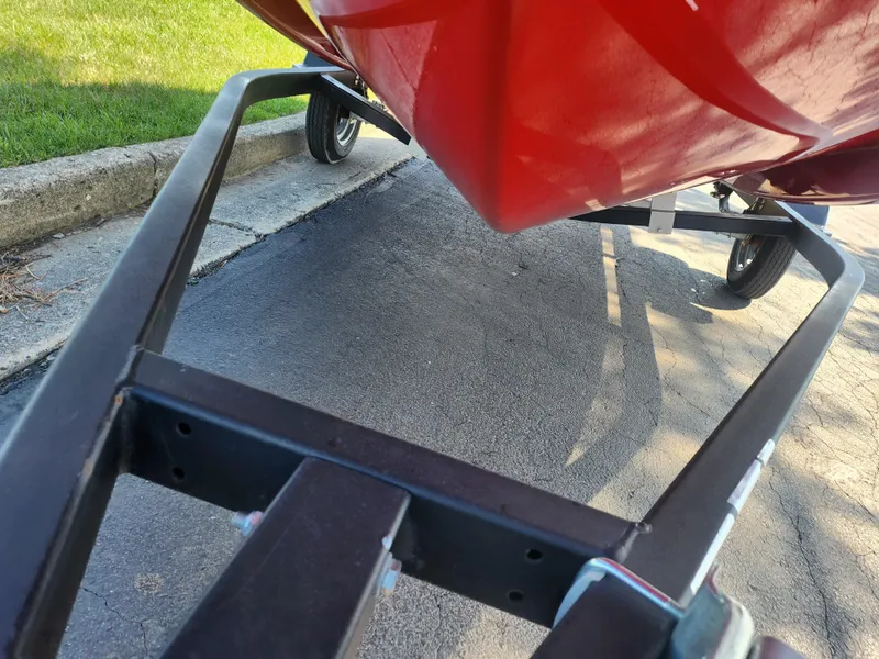 Slide: The Image of 2023 Bayliner Element M15 on trailer, red hull, parked on pavement. - 7