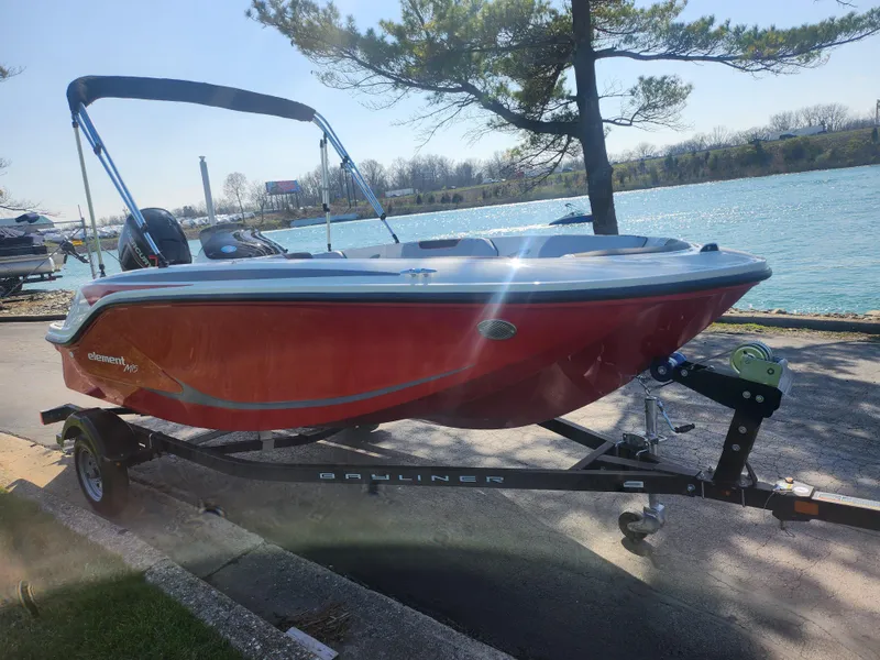 Slide: The Image of 2023 Bayliner Element M15 boat on trailer by a lakeside, under clear sky. - 8