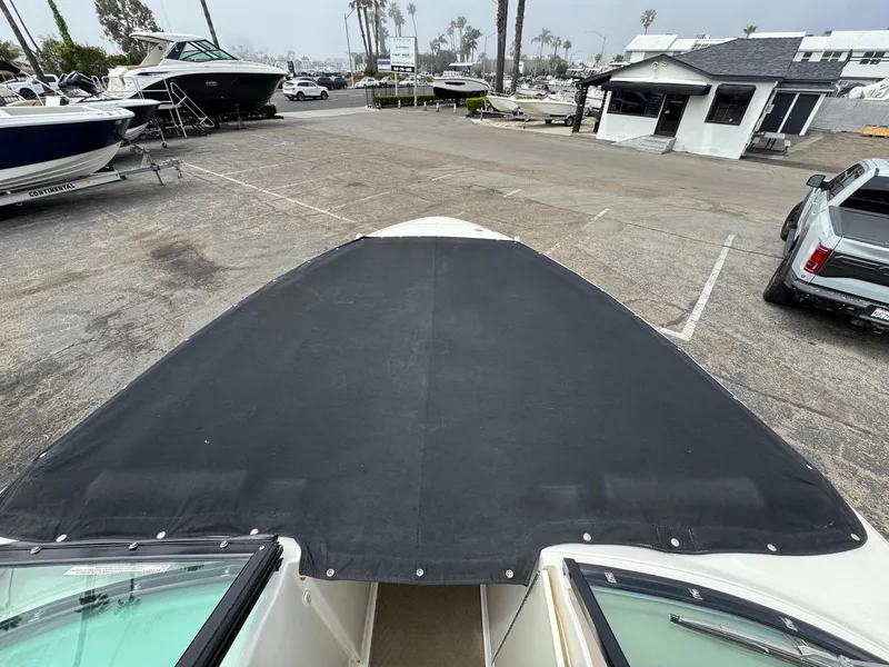 Slide: The Image of 2012 Sea Ray 250 SLX boat with black cover in a marina parking lot. - 13