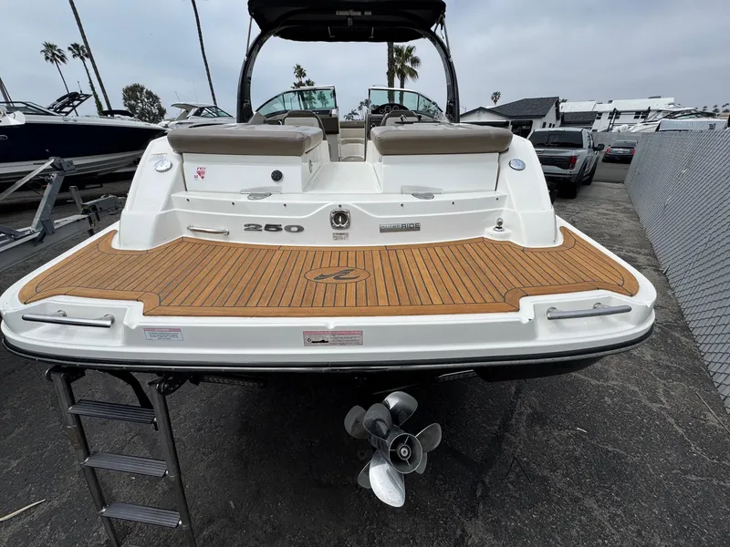 Slide: The Image of 2012 Sea Ray 250 SLX boat with teak swim platform and ladder, docked at marina. - 14